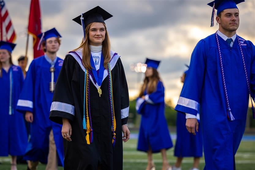 Students in blue robes graduate